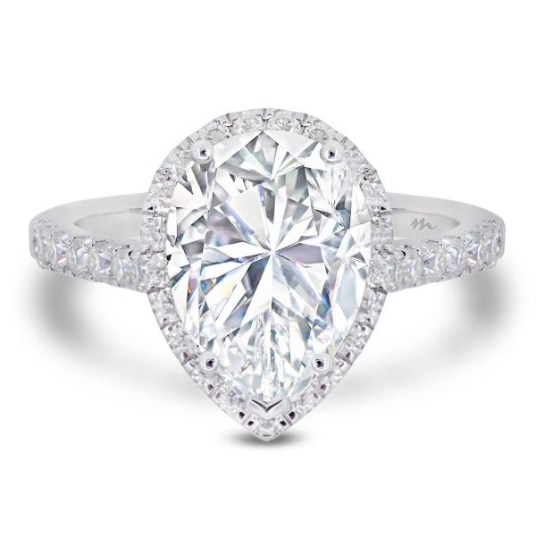 Faith Ring With A Large Pear Moissanite In A Halo Design And Diamond Encrusted Stones.