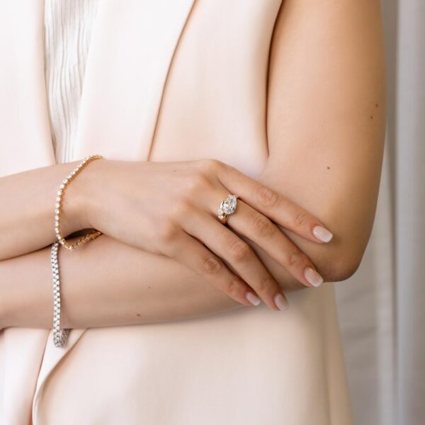 Model Wears Alana Yellow Gold Lab Grown Diamond East West Set Pear Under Rail 3 Rounds Curved Plain Band Ring