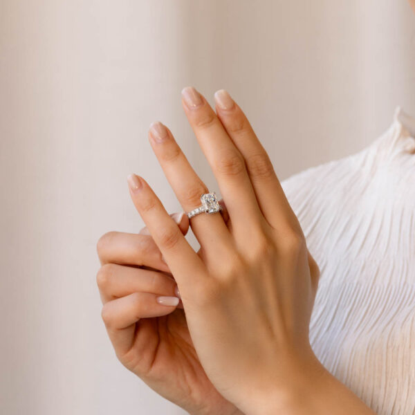 Model Wears Kathleen White Gold Lab Grown Diamond Radiant Under Rail Prong Set Solid Half Band Ring